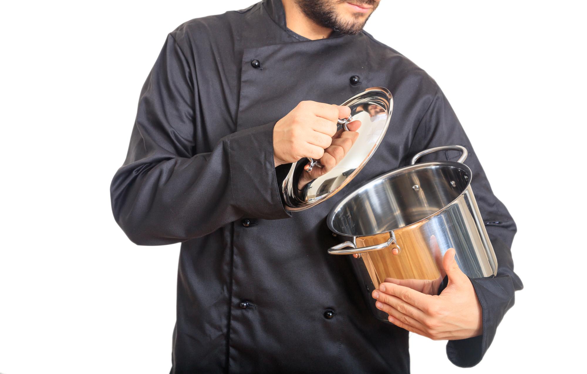 Instructor demonstrating cooking technique in a modern kitchen